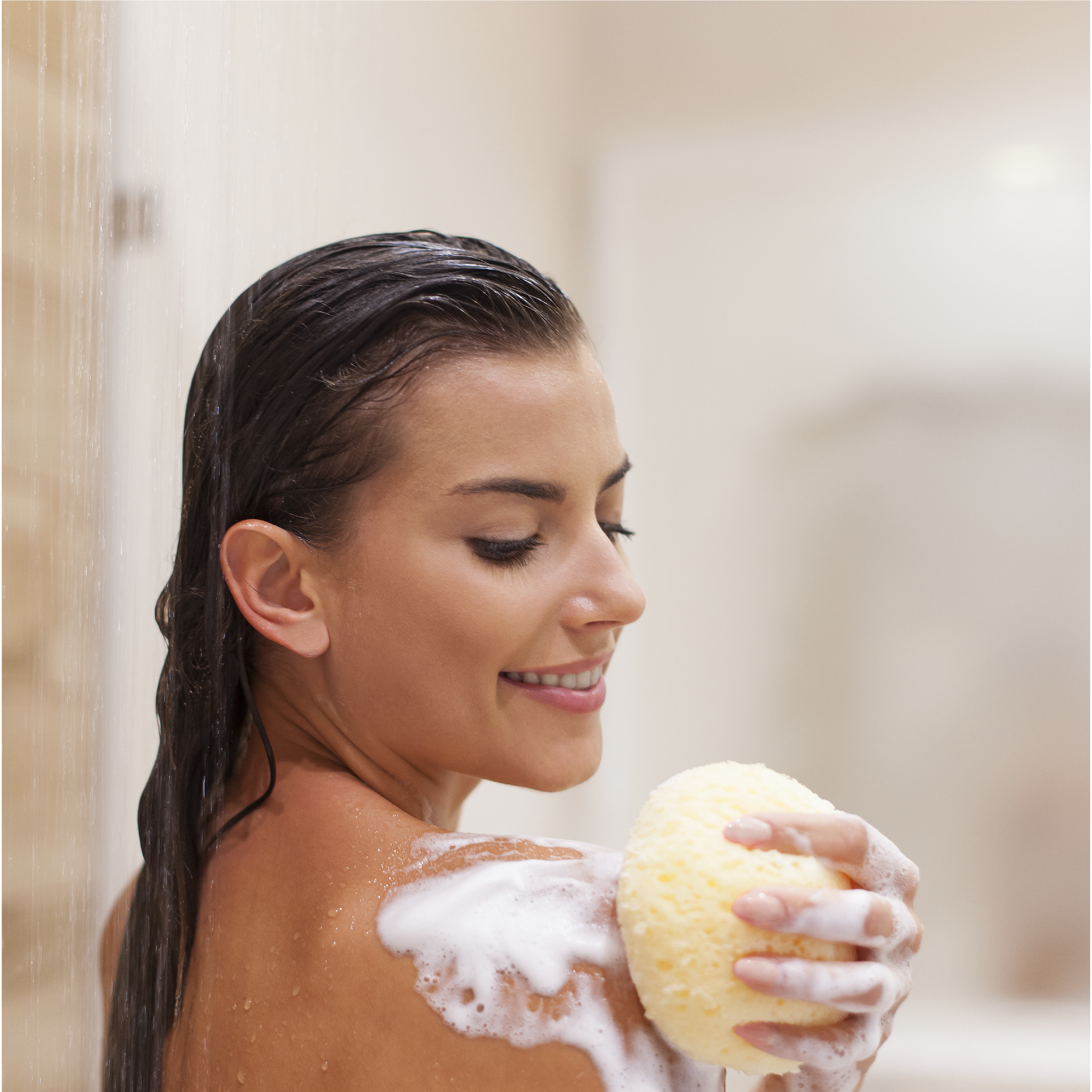 Woman with a sponge and sea buckthorn natural soap in a bathroom setting