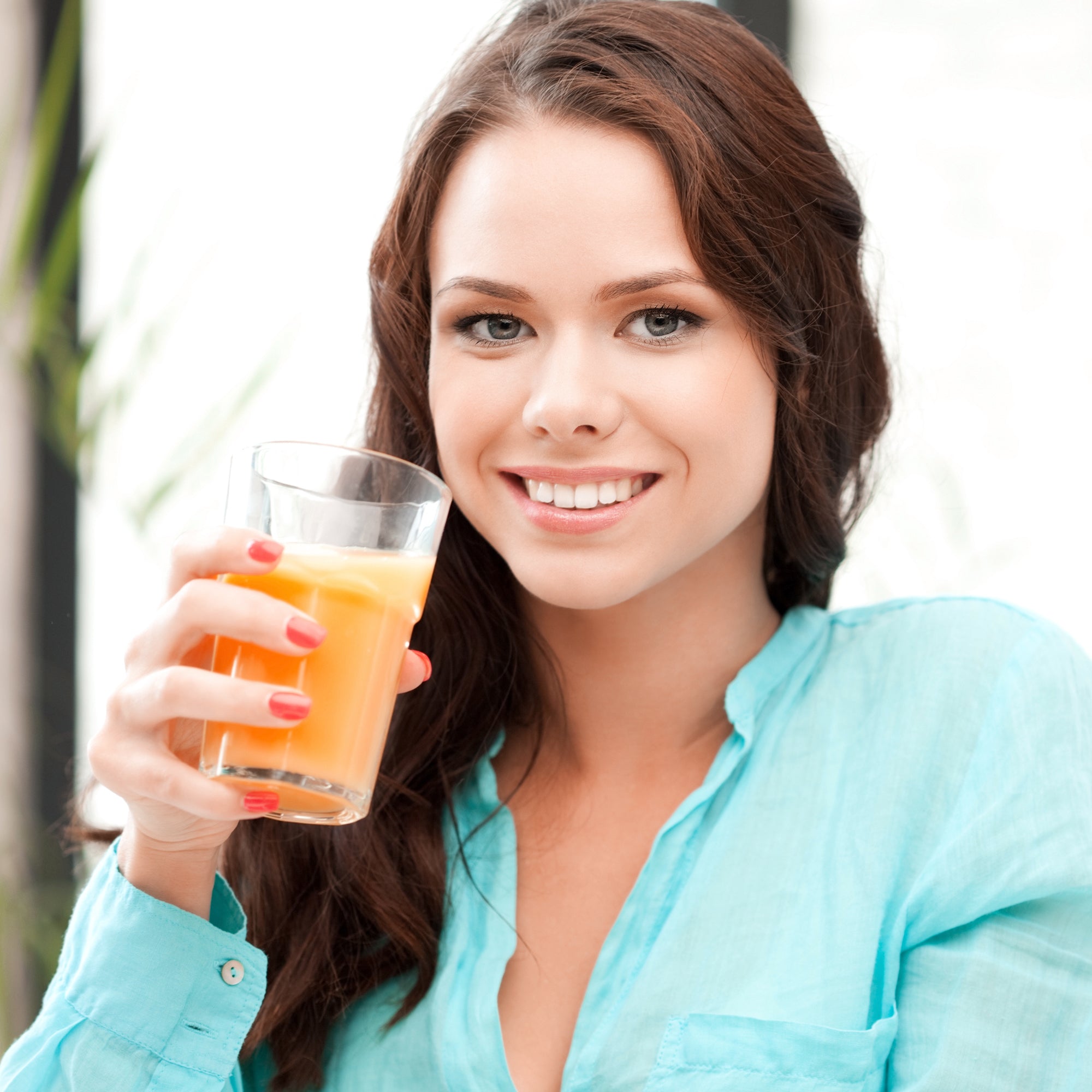 A woman having a glass of sea Buckthorn FemWell juice for women